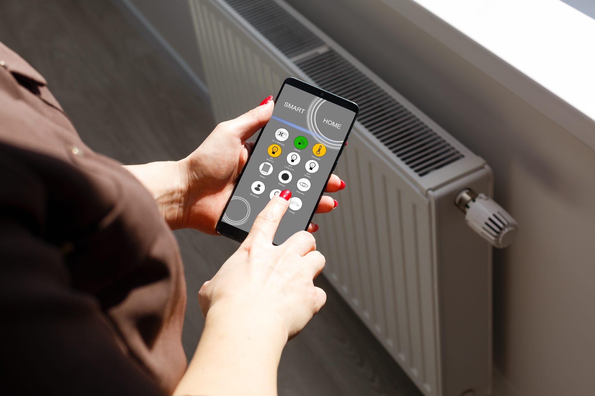 une femme controlant un radiateur avec son téléphone