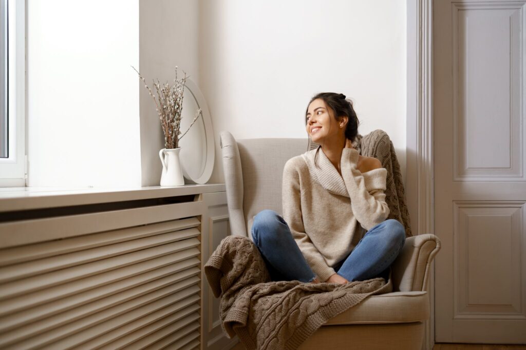 une femme assise devant un radiateur